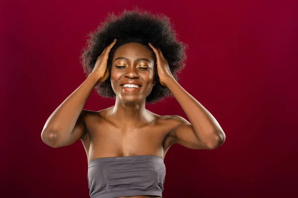 Happy positive woman touching her curly hair — Stock Photo, Image