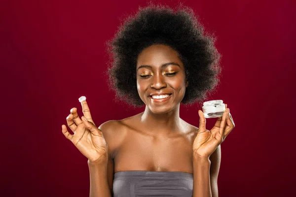 Joyful happy young woman applying facial cream — Stock Photo, Image