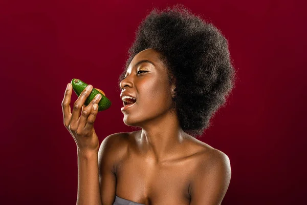 Красивая афро-американка ест авокадо — стоковое фото