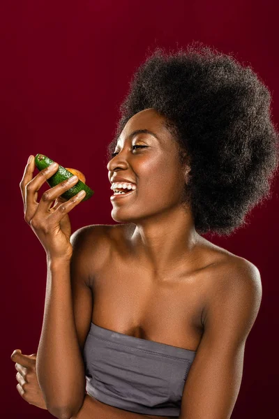 Mulher feliz positivo de pé com uma peça de abacate — Fotografia de Stock