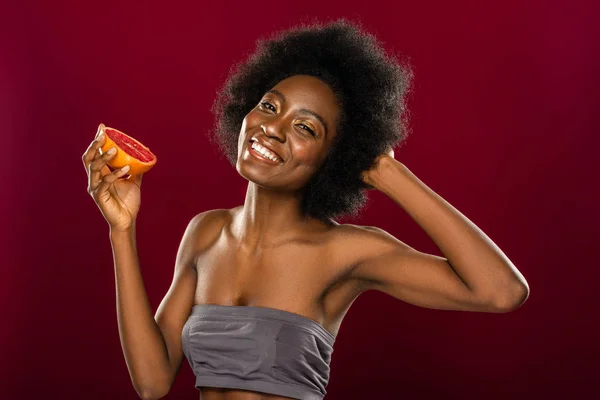 Encantada mulher bonita de pé com uma metade toranja — Fotografia de Stock