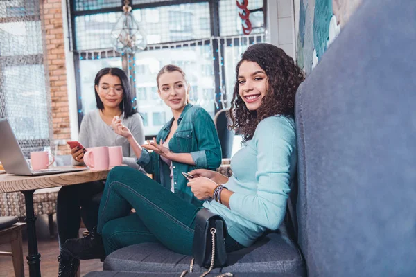 Delighted nice woman sitting together with her friends — Stock Photo, Image