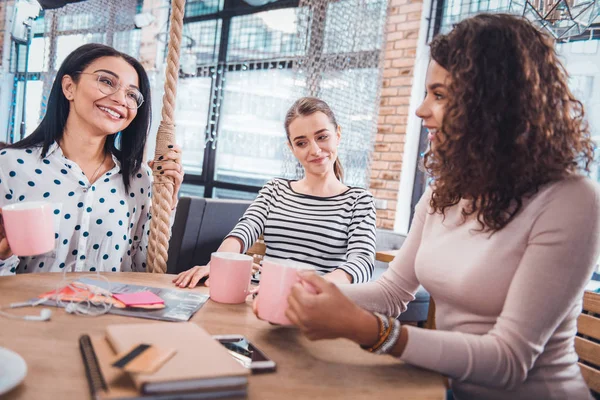 Mujeres positivas felices sentadas alrededor de la mesa — Foto de Stock