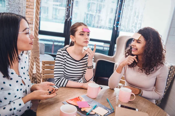 Belles femmes positives jouant à un jeu de devinettes — Photo