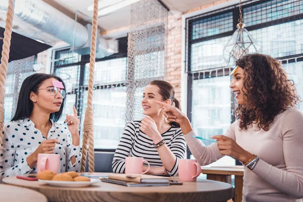 Positive nice woman pointing at her friend — Stock Photo, Image