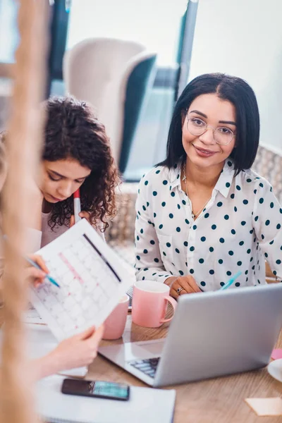 Blij mooie vrouw achter de laptop zit — Stockfoto