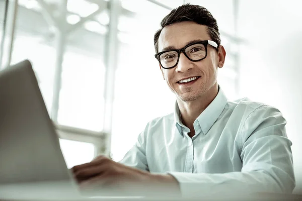 Positieve opgetogen man die recht naar de camera kijkt — Stockfoto