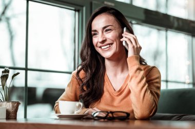Neşeli esmer telefon erkek arkadaşıyla konuşuyor