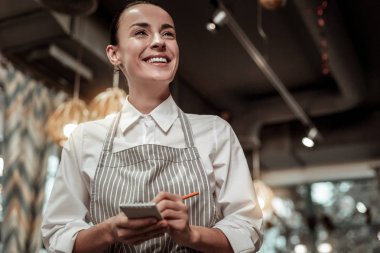 Komik bir şaka. Önlük giyen ve notlar onun defterini yapmak mutlu kafe işçi