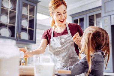 Gülümseyen ve küçük kızı tanımlama bilgisine işaret mutlu kadın