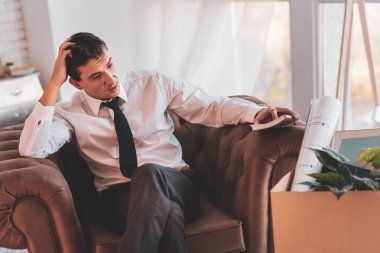 İşsiz mimar başını tırmalamak ve onun durumu hakkında düşünme