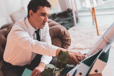 Bir klasör kutusundan şeyler çekerken dokunmadan sinirli mimar