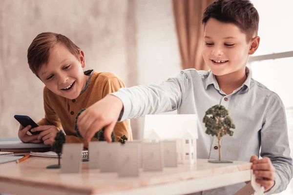 Dos curiosos colegiales construyendo modelo de casa unifamiliar — Foto de Stock