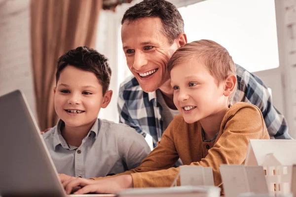 Smiling father feeling happy showing his children educational cartoon