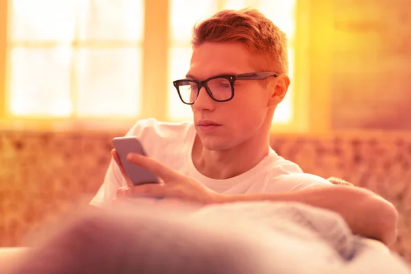 Serious concentrado chico mensajes de texto con su amigo — Foto de Stock