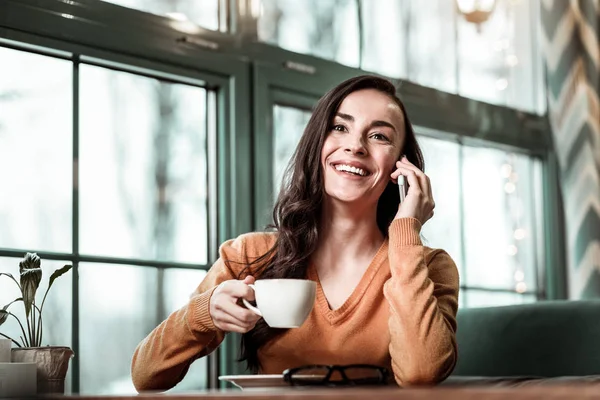 Szczęśliwa dziewczyna siedzi w jej ulubionej kawiarni — Zdjęcie stockowe