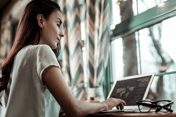 Koncentrerad kvinnlig person som tittar på skärmen på sin laptop — Stockfoto