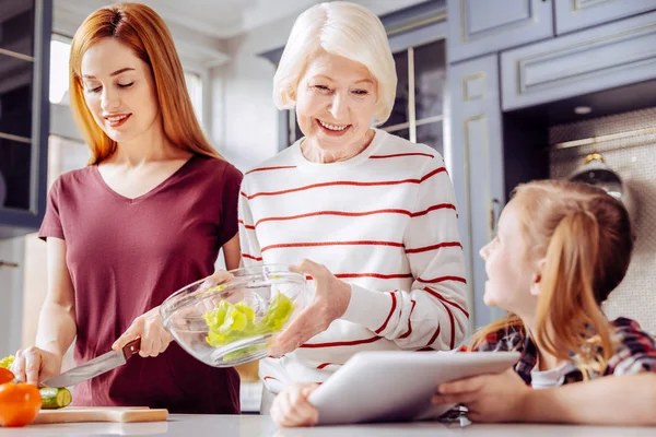 Dvě ženy vaření a při pohledu na obrazovku tabletu — Stock fotografie