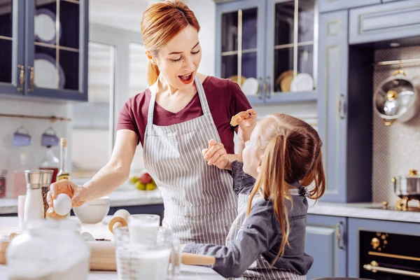 Gefühlsduselige Frau beeindruckt beim Anblick von Keks ihrer Tochter — Stockfoto