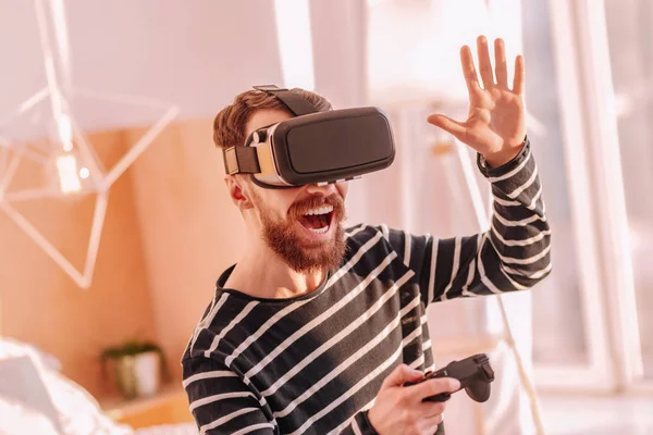 Skäggig man i Vr-glasögon som höjer ena handen upp — Stockfoto