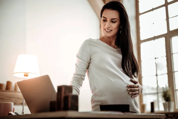 Entzückte positive Frau beim Blick auf den Laptop-Bildschirm — Stockfoto