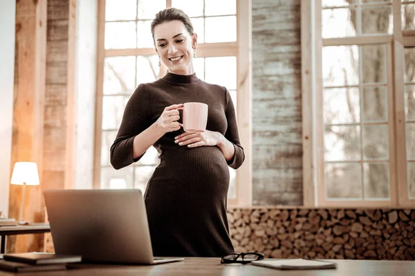 Niza embarazada mujer de negocios sosteniendo una taza con té — Foto de Stock