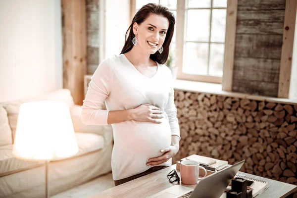 Mulher alegre positivo segurando sua barriga grande — Fotografia de Stock