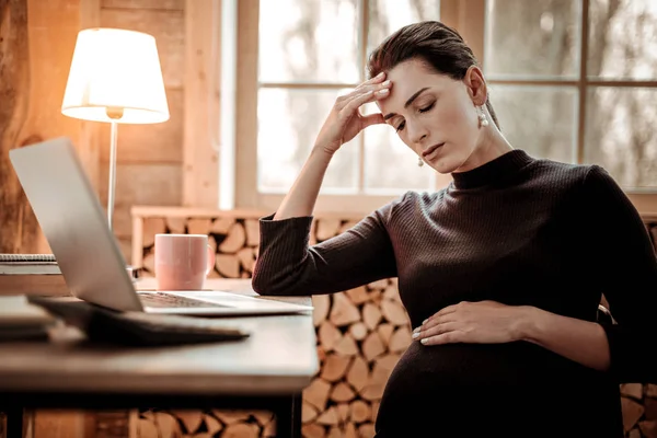 Sad cheerless pregnant woman holding her forehead — Stock Photo, Image