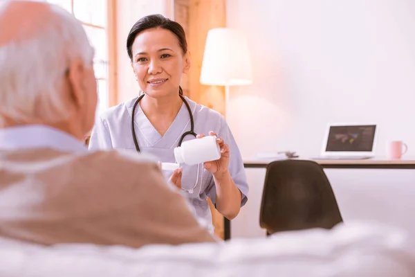 Позитивный восторженный медицинский работник разговаривает со своим пациентом — стоковое фото