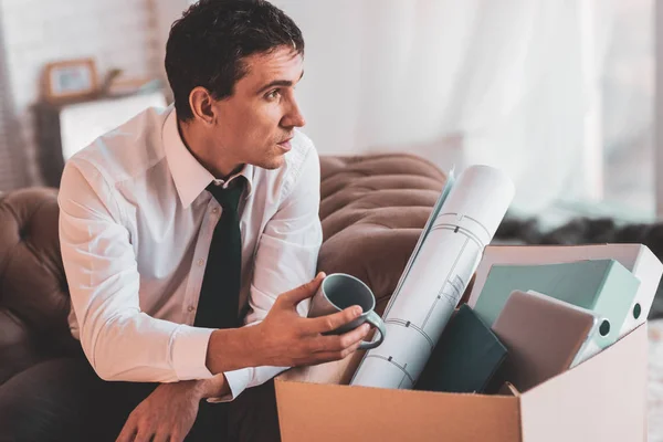 Ingeniero reflexivo mirando preocupado mientras sostiene una taza — Foto de Stock