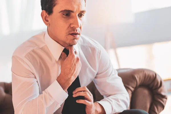 Verärgerter Arbeitsloser berührt Krawatte, während er sich unwohl fühlt — Stockfoto
