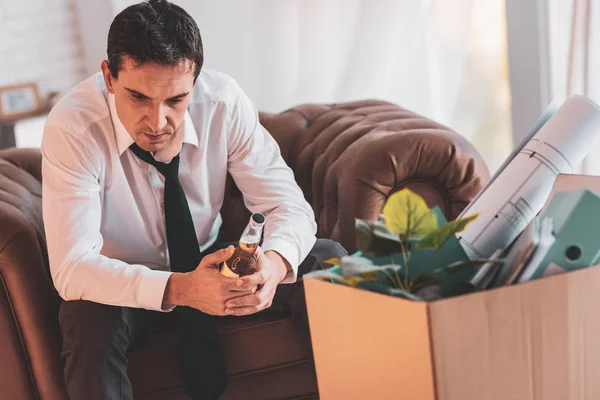 Ανήσυχος άνθρωπος που κρατά ένα μπουκάλι μετά από να χάσει τη δουλειά του — Φωτογραφία Αρχείου