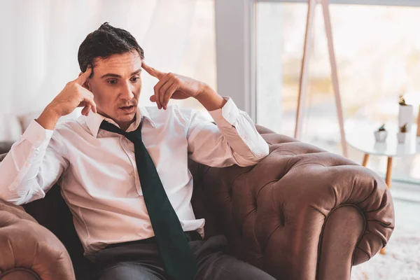 Hombre serio tocándose la cabeza mientras piensa —  Fotos de Stock