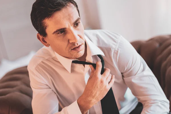 Hombre tranquilo mirando a la distancia y tocando su corbata —  Fotos de Stock