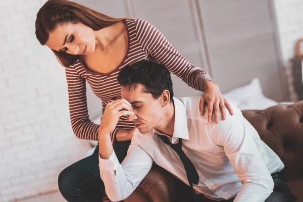 Depressiver Mann schließt die Augen und eine Frau sitzt in der Nähe — Stockfoto