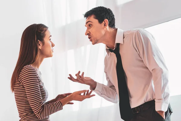 Expressive couple looking at each other while having an unpleasant talk — Stock Photo, Image