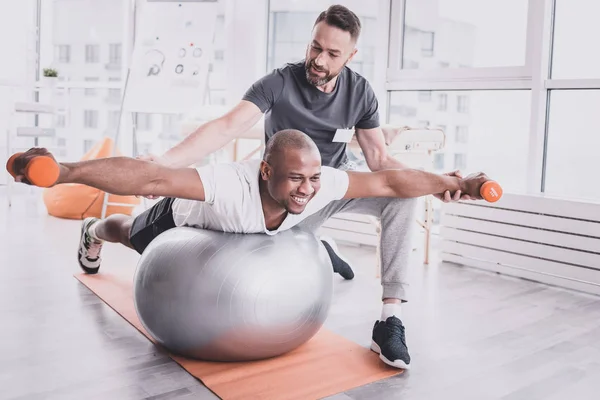 Blij Afrikaanse mannelijke persoon opheffing van halters in sportschool — Stockfoto