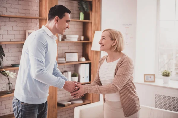 Positivo encantado hembra rubia estrechando la mano con el visitante — Foto de Stock