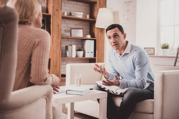 Bezorgd brunette mannelijke persoon in gesprek met zijn therapeut — Stockfoto