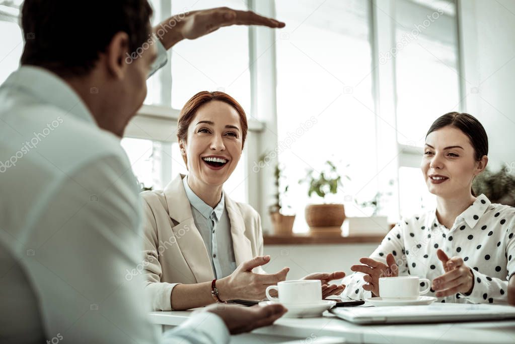 Cheerful female person laughing at funny situation