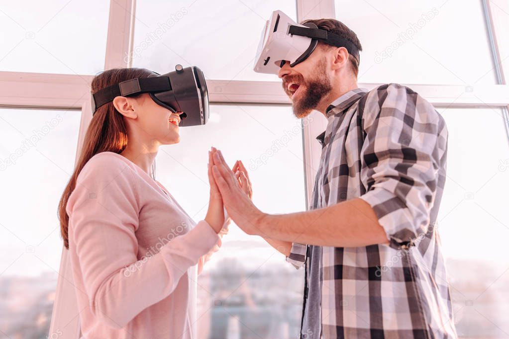 Creative couple standing together enjoying virtual reality