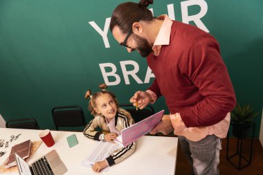 İyi cevap. Koyu renk saçlı sakallı yetişkin öğretmen memnun seyir gözlük takıyor