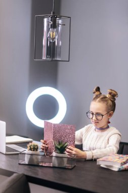 Mavi gözlü sevimli uzun saçlı kız beyaz süveterli iyi vakit geçiriyor