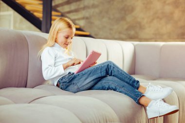 Küçük kadın yumuşak kanepede oturan memnun