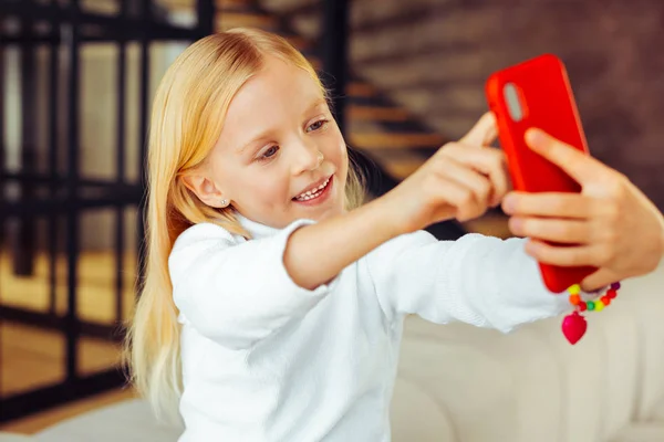 Θετική ενθουσιασμένος ξανθό κορίτσι λαμβάνοντας εικόνα σχετικά με το gadget — Φωτογραφία Αρχείου