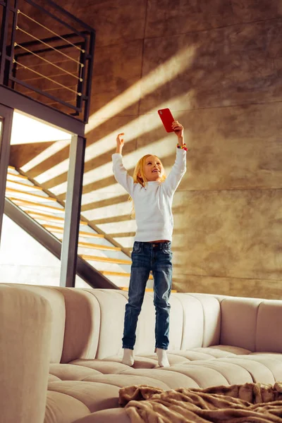 Positiv entzücktes Kind beim Betrachten ihres Gadgets — Stockfoto