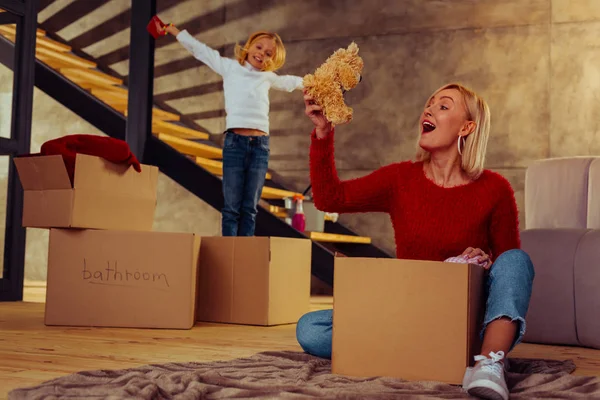 Lykkelig kvinnelig person som ser på babyens leketøy – stockfoto