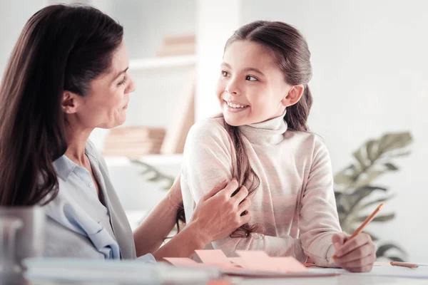 Pequeña niña de ojos avellanos que tiene una chispa de inspiración con su madre — Foto de Stock