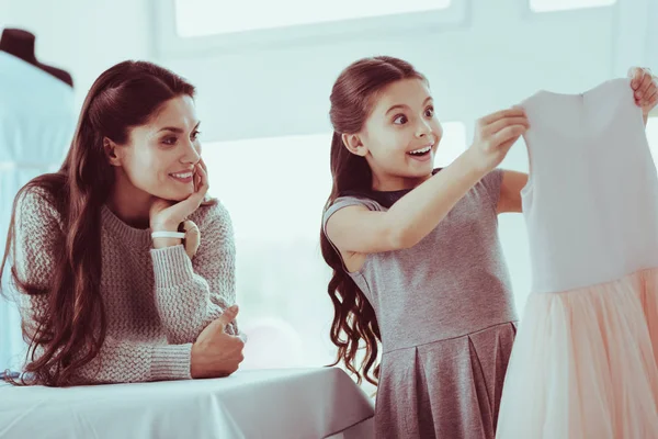 Careful mother presenting her daughter a dress — Stock Photo, Image