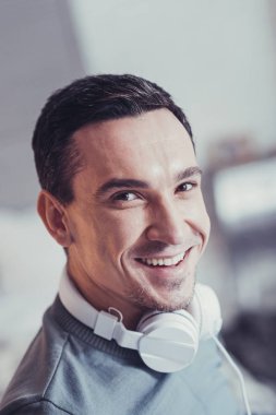 Kulaklıklar giyen güzel pozitif adam
